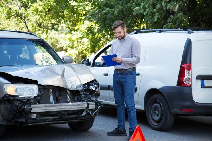 mann forsikringsagent med bilforsikring blank mot ødelagt bil